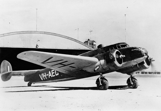 Stejné letadlo VH-AEC ve válečných barvách na letišti Archerfield v roce 1942. Dobře patrné je jméno Inlander na přídi. Podobný kamuflážní nátěr nosily za války i nkteré další australské letouny Elecgtra (foto Quantas Heritage Collection/Len Dobbin, via Ron Cuskelly)